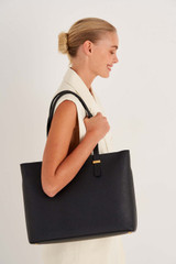 Profile view of model wearing the Oroton Anika 15" Tote & Cover in Black and Pebble leather for Women