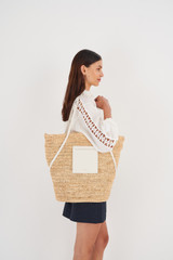 Profile view of model wearing the Oroton Jensen XL Tote in Nat/Paper White and Smooth Leather and Crocheted Straw for Women