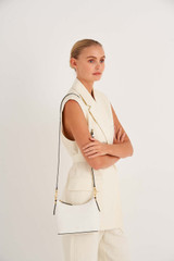 Profile view of model wearing the Oroton Anika Crossbody in Cream and Pebble leather for Women