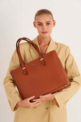 Profile view of model wearing the Oroton Anika 15" Tote & Cover in Cognac and Pebble leather for Women