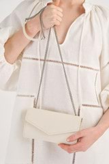 Profile view of model wearing the Oroton Bella Clutch Wallet in Milk/Matte Silver and Soft Saffiano for Women