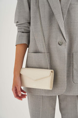 Profile view of model wearing the Oroton Bella Clutch Wallet in Milk and Soft Saffiano for Women