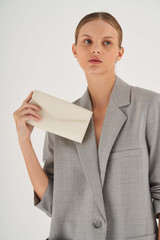 Profile view of model wearing the Oroton Bella Clutch Wallet in Milk and Soft Saffiano for Women