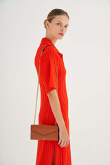 Profile view of model wearing the Oroton Bella Clutch Wallet in Cognac and Soft Saffiano for Women