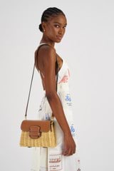 Profile view of model wearing the Oroton Carter Collectable Small Day Bag in Natural/Brandy and Smooth Leather and Wicker for Women