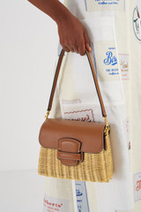 Profile view of model wearing the Oroton Carter Collectable Small Day Bag in Natural/Brandy and Smooth Leather and Wicker for Women