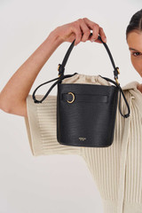 Profile view of model wearing the Oroton Audrey Bucket Bag in Black and Saffiano And Smooth Leather for Women