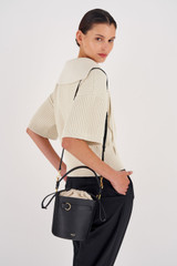 Profile view of model wearing the Oroton Audrey Bucket Bag in Black and Saffiano And Smooth Leather for Women
