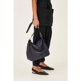 Profile view of model wearing the Oroton Byron Large Hobo in Midnight Blue and Pebble Leather for Women