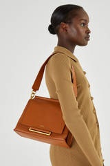 Profile view of model wearing the Oroton Elm Medium Day Bag in Brandy and Pebble leather with smooth leather trims for Women