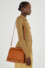 Profile view of model wearing the Oroton Elm Medium Day Bag in Brandy and Pebble Leather With Smooth Leather Trim for Women