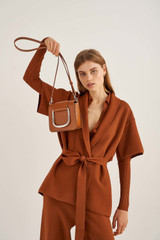 Profile view of model wearing the Oroton Cole Mini Day Bag in Cognac and Smooth Leather for Women