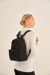 Profile view of model wearing the Oroton Elsie Nylon Backpack in Black and Nylon And Pebble Leather for Women