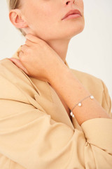 Profile view of model wearing the Oroton Farah Bracelet in Silver and Brass Base With Rhodium Plating for Women