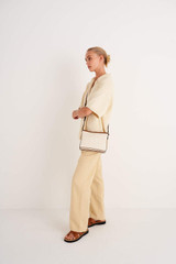 Profile view of model wearing the Oroton Ariel Crossbody in Natural/Cognac and Coated canvas for Women
