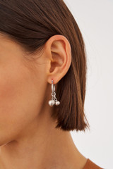 Profile view of model wearing the Oroton Ceres Hoops in Worn Silver and Brass Base With Rhodium Plating for Women