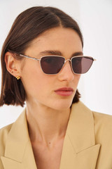Profile view of model wearing the Oroton Aspen Sunglasses in Gold and Metal for Women