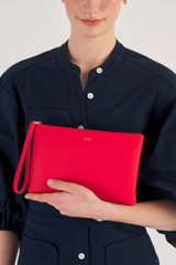 Profile view of model wearing the Oroton Eve Medium Pouch in Apple and Pebble leather for Women