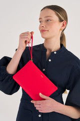 Profile view of model wearing the Oroton Eve Medium Pouch in Apple and Pebble leather for Women