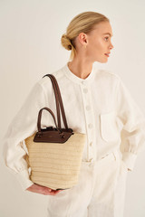 Profile view of model wearing the Oroton Claire Medium Tote in Natural/Cognac and Paper Straw And Pebble Leather for Women