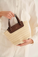 Profile view of model wearing the Oroton Claire Small Tote in Natural/Cognac and Paper Straw And Pebble Leather for Women