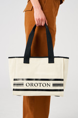 Profile view of model wearing the Oroton Lara Medium Tote in Natural and Recycled Canvas for Women