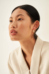 Profile view of model wearing the Oroton Fiona Mini Chunky Hoops in Gold and Brass Base With 18CT Gold Plating for Women