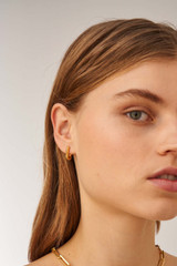 Profile view of model wearing the Oroton Lacey Small Hoops in Worn Gold and Brass Base With 18CT Gold Plating for Women