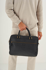 Profile view of model wearing the Oroton Lucas 13" Griptop in Black and Pebble Leather for Men