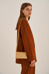 Profile view of model wearing the Oroton Heath Wallet Crossbody in Mango and Smooth Leather for Women