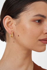 Profile view of model wearing the Oroton Lacey Medium Hoops in Worn Gold and Brass Base With 18CT Gold Plating for Women