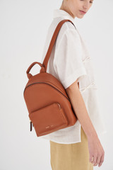 Profile view of model wearing the Oroton Lilly Small Backpack in Cognac and Pebble leather/Nylon for Women