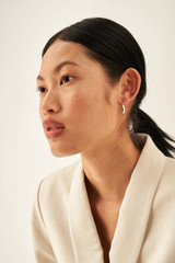 Profile view of model wearing the Oroton Fiona Mini Chunky Hoops in Silver and Brass Base With Rhodium Plating for Women