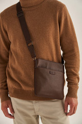 Profile view of model wearing the Oroton Harry Pebble Messenger Bag in Cedar and Pebble Leather for Men