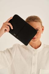 Profile view of model wearing the Oroton Lilly Medium Zip Pouch in Black and Pebble Leather for Women