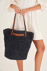 Profile view of model wearing the Oroton Lilly Crochet Medium Tote in Denim Blue and Paper Straw and Smooth Leather Trim for Women