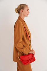 Profile view of model wearing the Oroton Lilly Zip Top Crossbody in Crimson and Pebble leather for Women