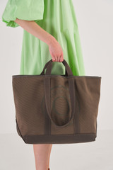 Profile view of model wearing the Oroton Kane Large Shopper Tote in Khaki and Recycled Canvas for Women