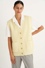 Profile view of model wearing the Oroton Knit Vest in Butter and 100% Wool for Women