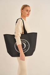 Profile view of model wearing the Oroton Kaia Shopper Tote in Black and Coated Canvas for Women