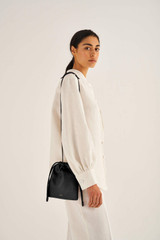Profile view of model wearing the Oroton Lilia Crossbody in Black and Smooth Leather for Women
