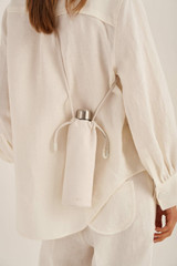 Profile view of model wearing the Oroton Lilia Water Bottle Holder in Pure White and Smooth Leather for Women