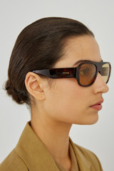 Profile view of model wearing the Oroton Gentry Sunglasses in Signature Tort and Acetate for Women