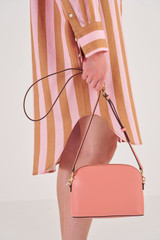 Profile view of model wearing the Oroton Inez Slim Crossbody in Pink Clay and Shiny Soft Saffiano for Women