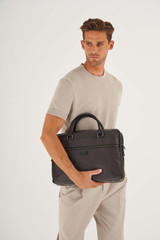 Profile view of model wearing the Oroton Lucas 13" Griptop in Chocolate/Black and Pebble Leather for Men