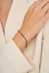 Profile view of model wearing the Oroton Juniper Bracelet in Gold/Navy and Brass Base With 18CT Gold Plating for Women