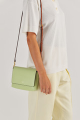 Profile view of model wearing the Oroton Harriet Crossbody in Pear and Saffiano Leather With Smooth Leather Trim for Women