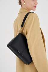 Profile view of model wearing the Oroton Emma Small Day Bag in Black and Pebble Leather for Women