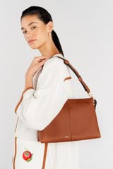 Profile view of model wearing the Oroton Emma Medium Day Bag in Cognac and Pebble Leather for Women