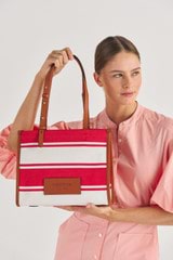 Profile view of model wearing the Oroton Daisy Small Tote in Apple/Cream and Stripe Canvas Fabric and Smooth Leather Trim for Women